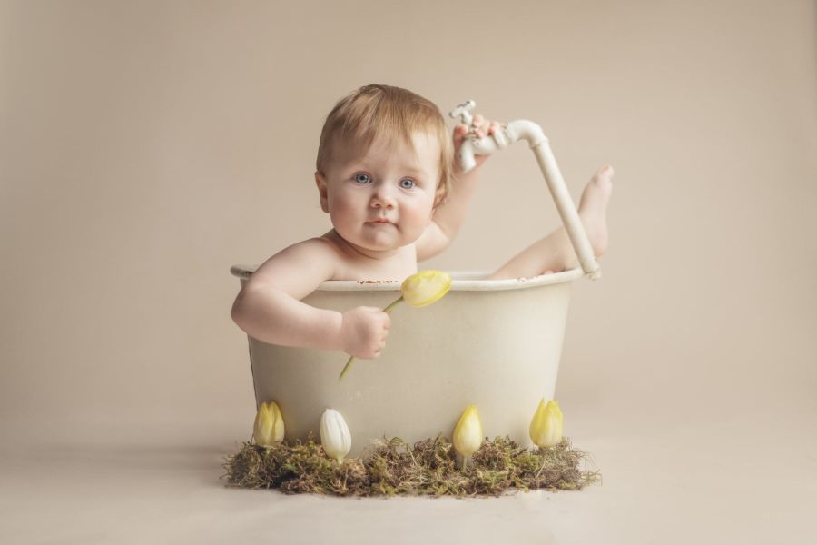 Milchbad nach einem Smash Cake Shooting. Ein Baby sitzt in einer kleinen Badewanne.