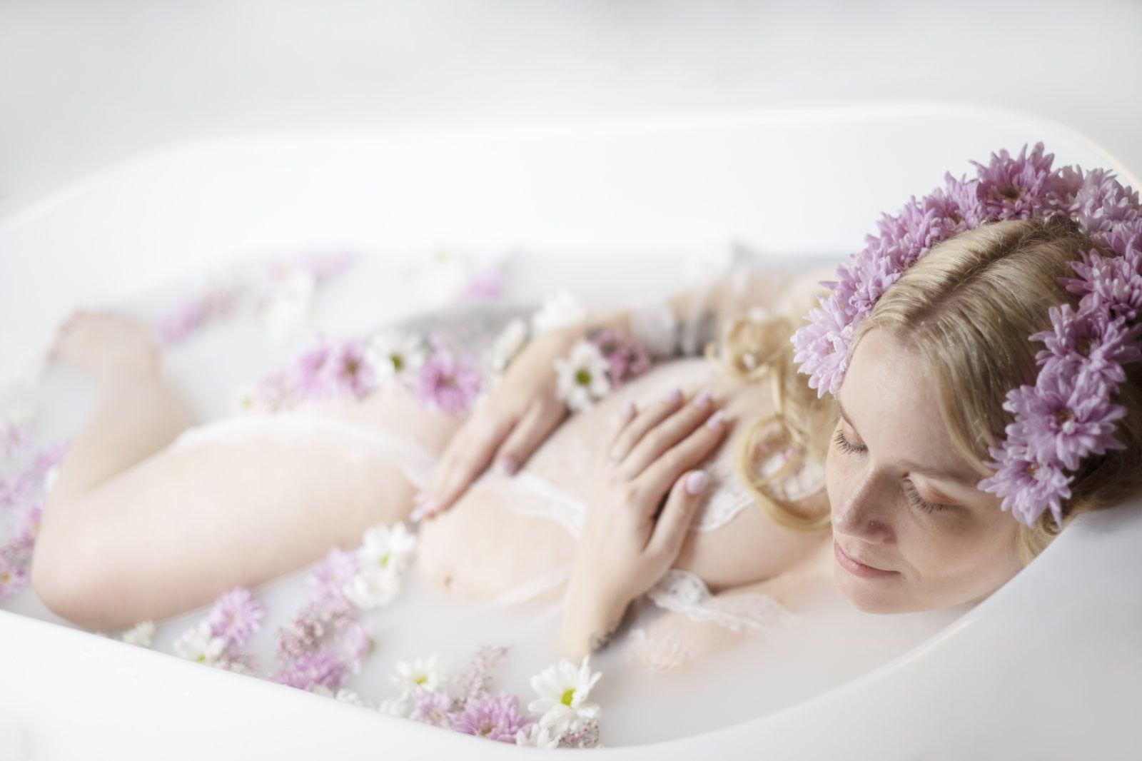 Babybauch Fotoshooting in der Badewanne. Das Bild zeigt eine schwangere Frau, die in einer Badewanne liegt.