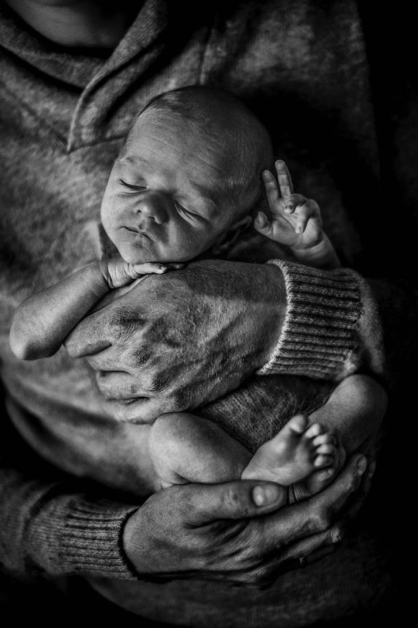 Das Bild zeigt 5 Kinder und ein Baby. In der Mitte steht der große Bruder, der das Baby auf dem Arm hält, rechts und links daneben die kleineren Schwestern und neben denen die noch kleineren Schwestern. Jedes Kind lehnt den Kopf an die Schulter des nächst größeren Kindes.